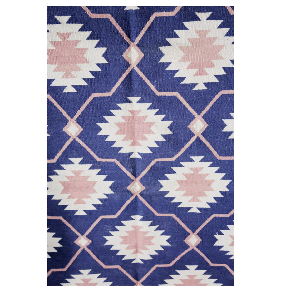 Discover the artistry behind the weaving process of Iznik Rose Pink Flatweave Dhurrie Rug, a romantic addition to your decor.