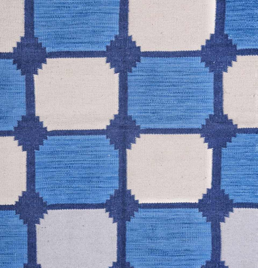 Dive into the meticulous craftsmanship of the Blue Tile Flatweave Dhurrie Rug, inspired by timeless tile motifs.