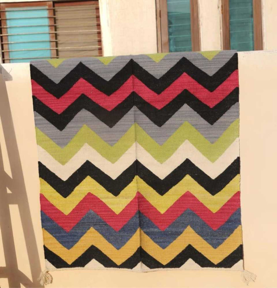 Multi Chevron Dhurrie Rug with mix colors and patterns outdoors